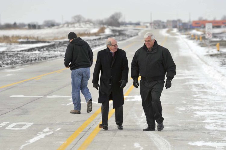 -Messenger photo by Hans Madsen Former Fort Dodge Mayor Terry Lutz, left, walks along a section of the newly opened First Avenue South with Decker Truck Line, Inc. Chairman of the Board Don Decker Thursday morning after the ribbon cutting for the new Decker Development Park on the east side of Fort Dodge. Decker was looking for the spot along the curb where two of his grandchildren had gotten to leave their hand and foot prints in the freshly poured concrete.